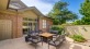 a patio with a table surrounded by chairs