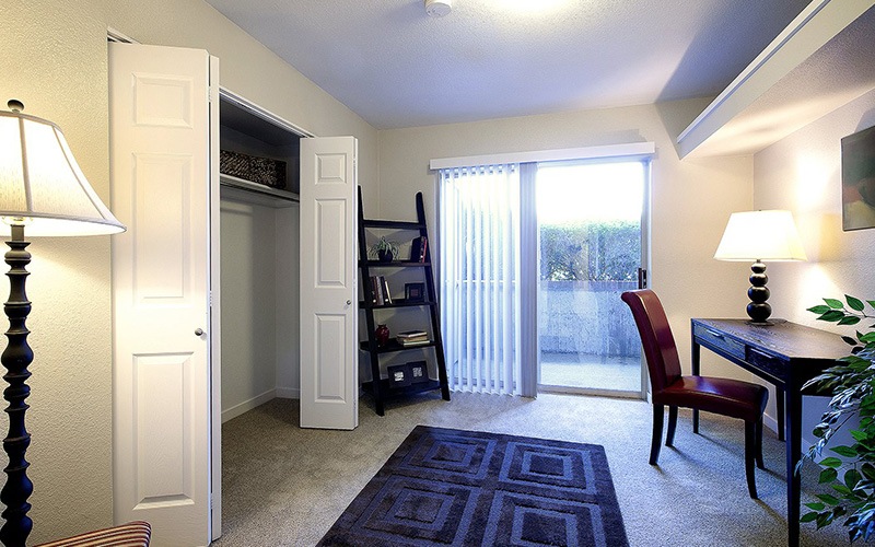 a living room with chairs closet and lamps